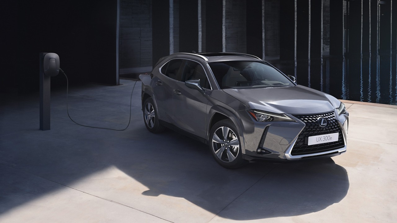 Joy Crookes leaning on the bonnet of a Lexus UX