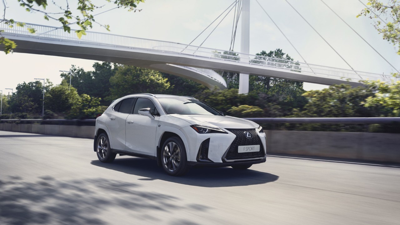 Joy Crookes leaning on the bonnet of a Lexus UX