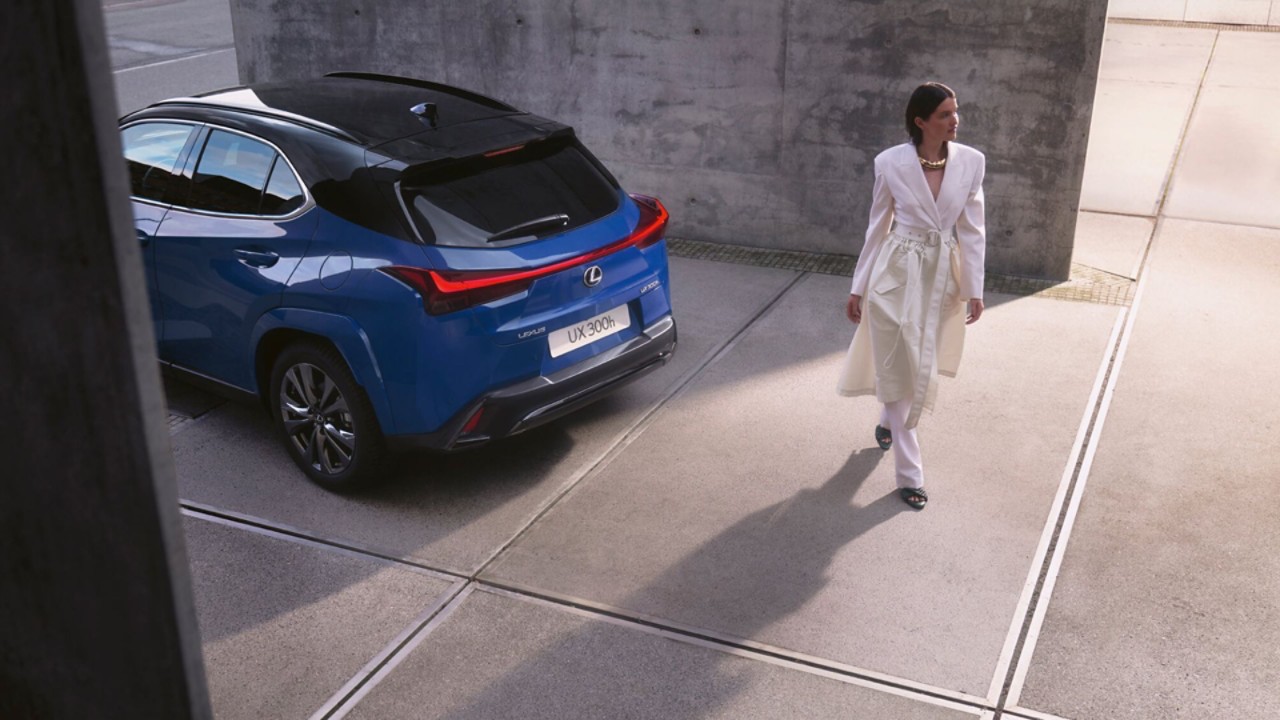A person stood next to a blue Lexus UX